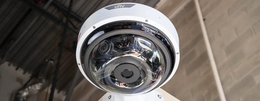 A large security camera mounted to a corner bracket with four lenses internally