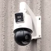 A large security camera mounted on a grey concrete wall, made by UNV